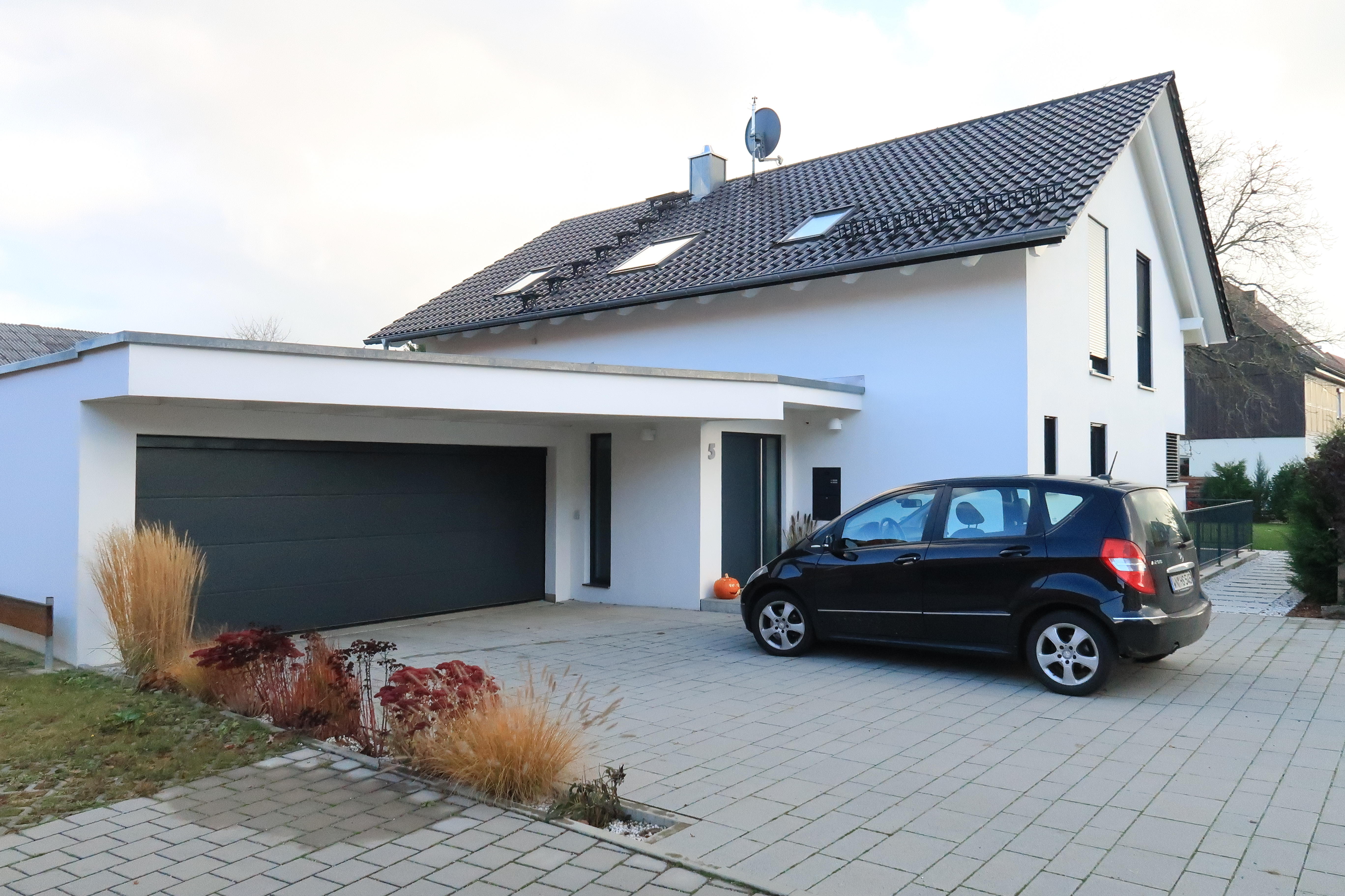 Ein freistehendes Haus mit großem Garten und Garage